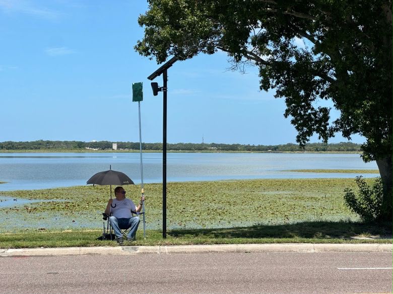 Local resident blocks Flock surveillance camera with cardboard sign